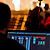A person operates a computer with audio mixing software, displaying various sound levels and settings, in a performance venue.