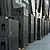 Row of large black speaker cabinets lined up on a stage, ready for a performance, with a backdrop featuring the year "1990."